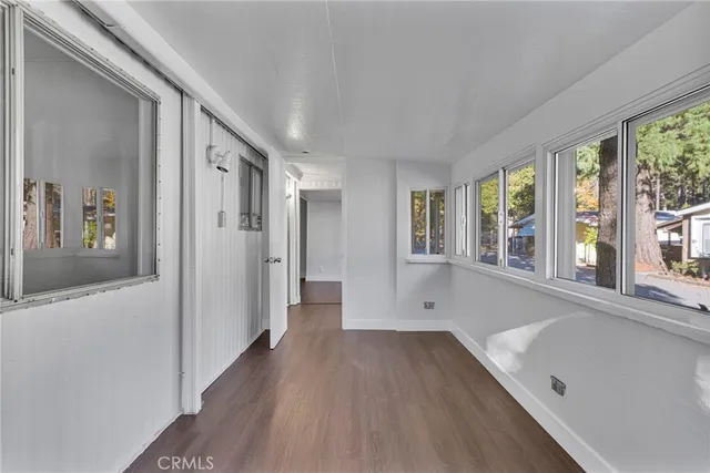 a view of hallway with a large window and wooden floor