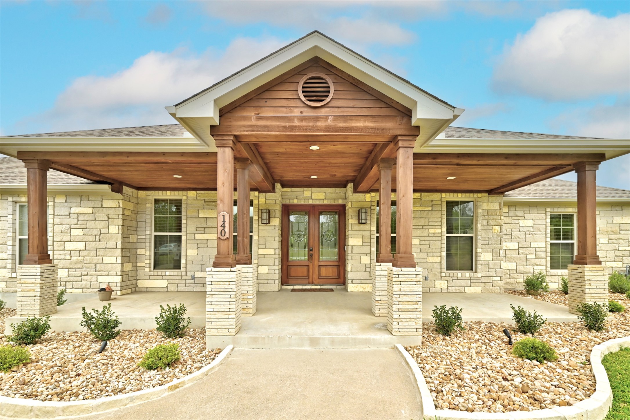 140 Winchester Road Bastrop, TX 78602 - Photo 1 of 36 Entrance to property with stone siding, a shingled roof, and largevcovered porch