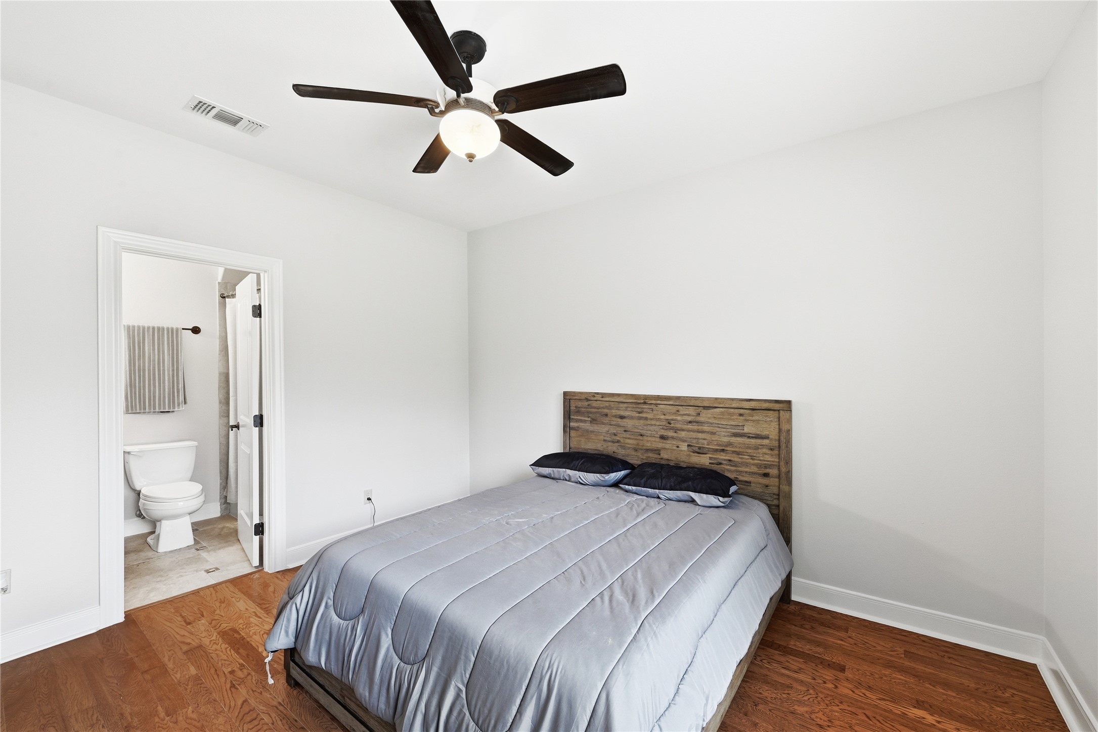 140 Winchester Road Bastrop, TX 78602 - Photo 28 of 36 Spare Bedroom 3 with dark wood-type flooring, a ceiling fan, and ensuite bath