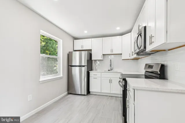 a kitchen with stainless steel appliances granite countertop a refrigerator sink and stove