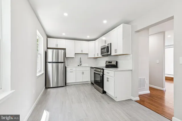 a kitchen with white cabinets and stainless steel appliances
