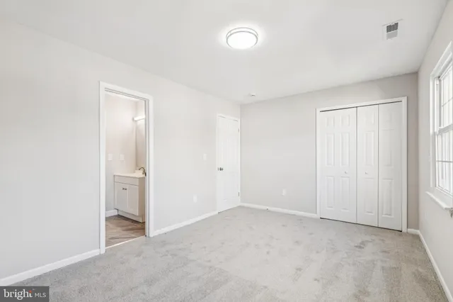 an empty room with windows and closet