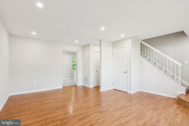 a view of empty room with wooden floor