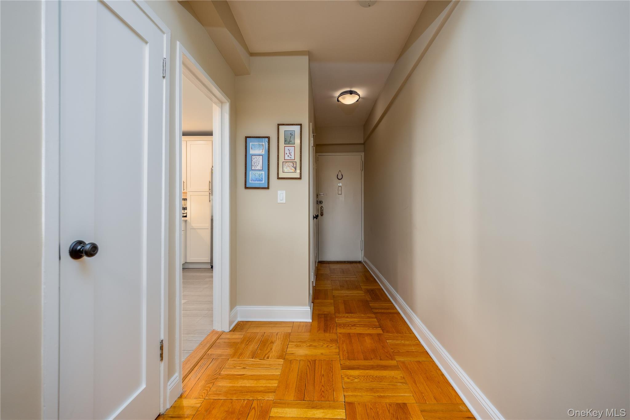 900 Palmer Road, Unit 9J Bronxville, NY 10708 - Photo 3 of 14 a view of a hallway with wooden floor and a bathroom