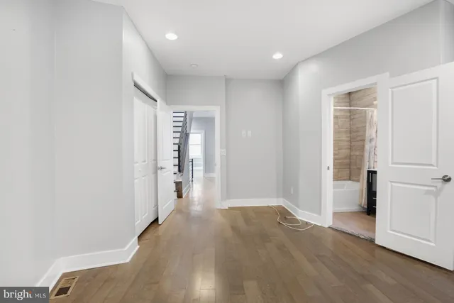 a view of a livingroom with wooden floor and stairs