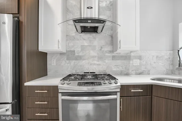 a kitchen with stainless steel appliances a refrigerator and a stove top oven