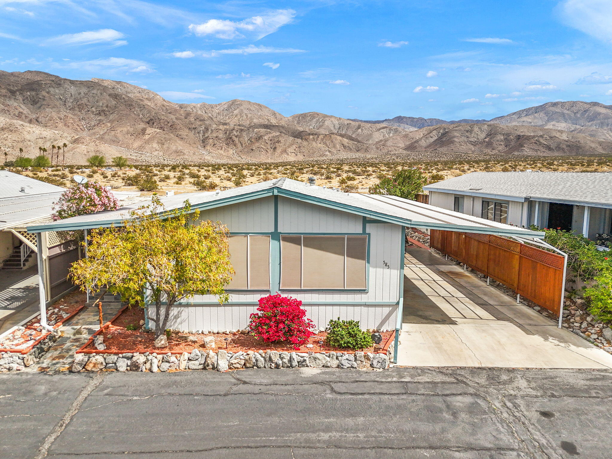 a front view of a house with a yard and mountain view