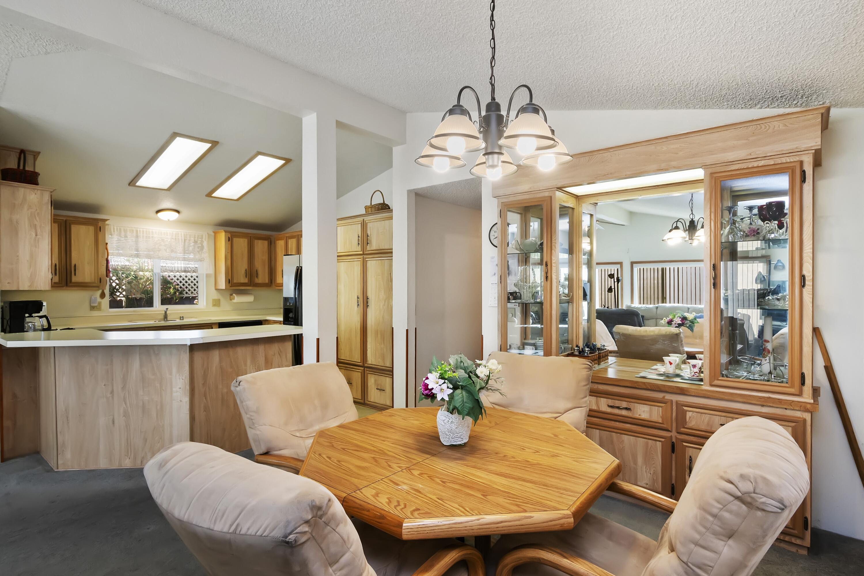 74711 Dillon Road, Unit 585 Desert Hot Springs, CA 92241 - Photo 20 of 60 a view of a dining room with furniture a chandelier and wooden floor