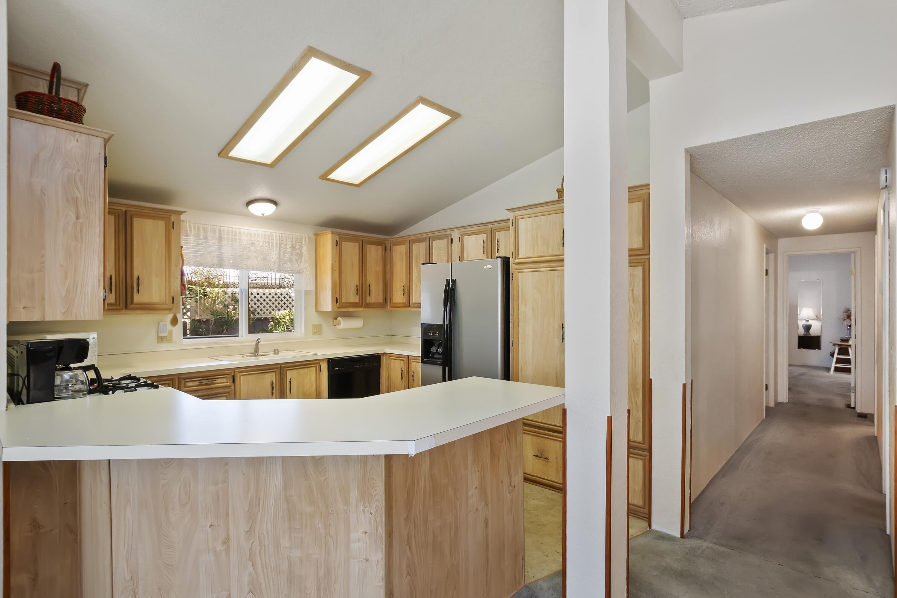 74711 Dillon Road, Unit 585 Desert Hot Springs, CA 92241 - Photo 22 of 60 a view of a kitchen with a sink dishwasher refrigerator stove and cabinets