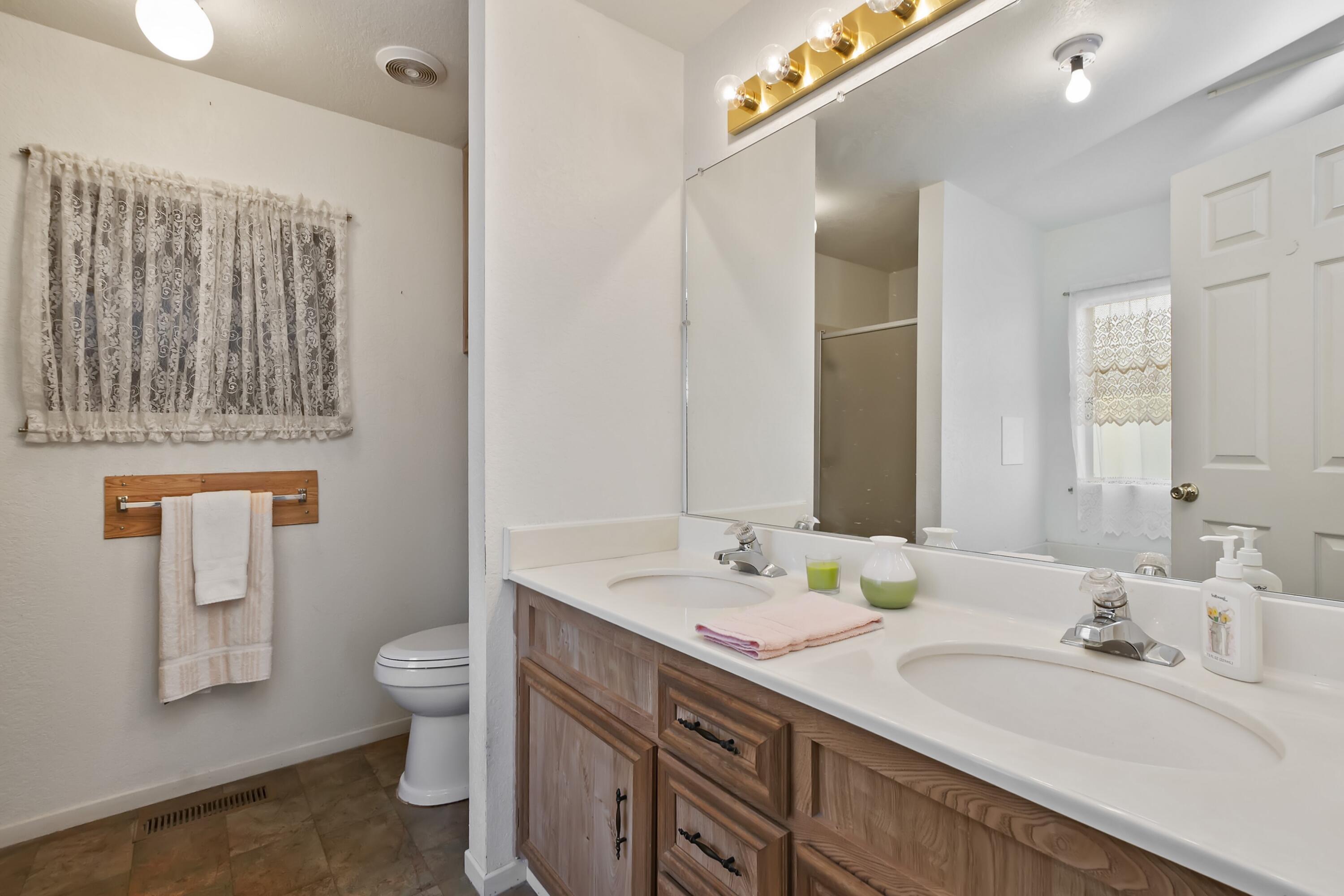 74711 Dillon Road, Unit 585 Desert Hot Springs, CA 92241 - Photo 31 of 60 a bathroom with a granite countertop double vanity sink a mirror and a toilet