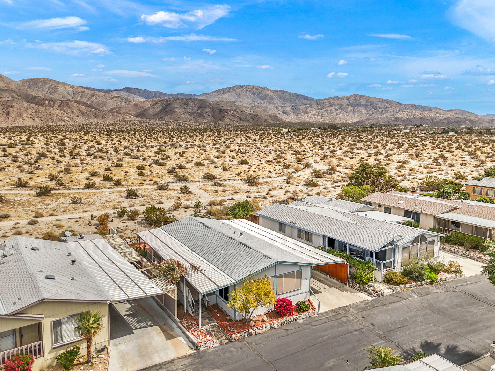 74711 Dillon Road, Unit 585 Desert Hot Springs, CA 92241 - Photo 39 of 60 an aerial view of residential houses with outdoor space and trees