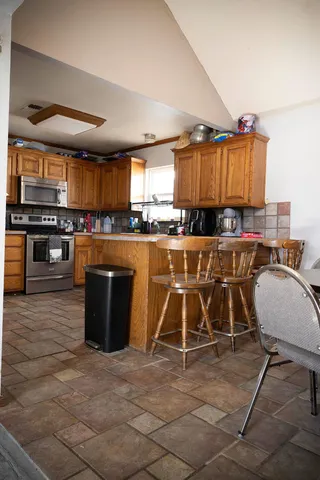 a kitchen with stainless steel appliances granite countertop a stove top oven a sink dishwasher and cabinets with wooden floor