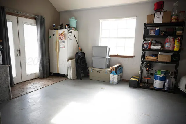 a view of a livingroom with fridge and workspace