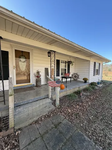 a view of a patio with table chairs and barbeque grill