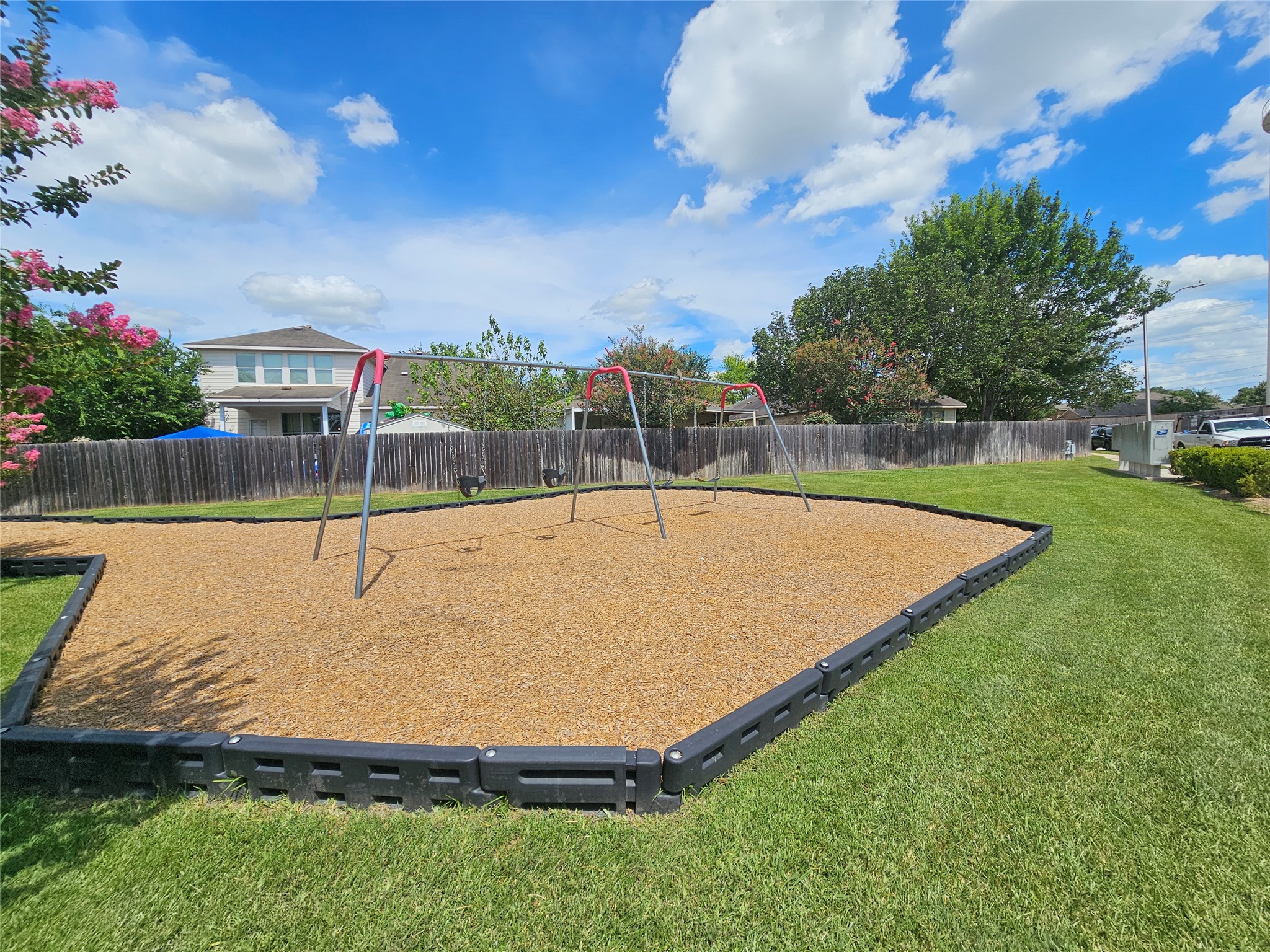 2035 Intrepid Drive Buda, TX 78610 - Photo 24 of 26 A community playground, perfect for outdoor enjoyment, features a swing set on wood chips and well-maintained green grass.
