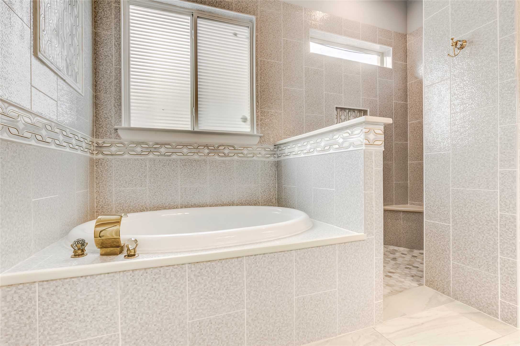 345 Fort Cobb Way Georgetown, TX 78628 - Photo 23 of 38 A tiled soaking tub sits adjacent to a separate walk-in shower under textured wall surrounds.