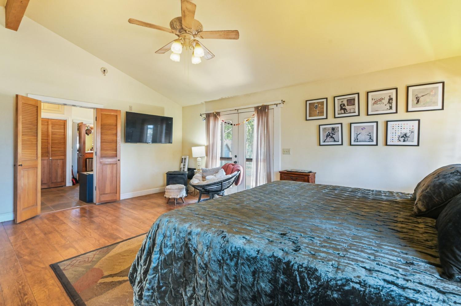 6640 Railroad Flat Road Mountain Ranch, CA 95246 - Photo 24 of 60 a spacious bedroom with a bed and a chandelier