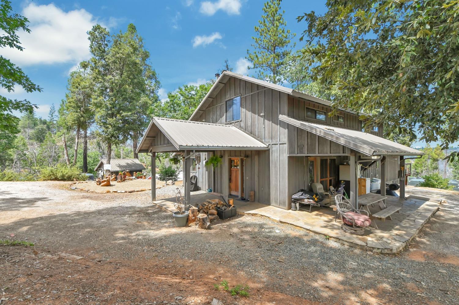 6640 Railroad Flat Road Mountain Ranch, CA 95246 - Photo 55 of 60 a backyard of a house with table and chairs under an umbrella