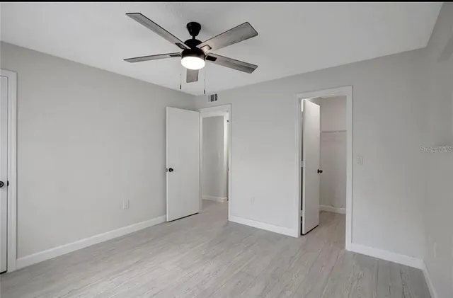 a view of an empty room with wooden floor