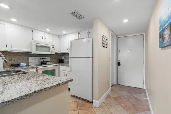a kitchen with granite countertop a refrigerator and a sink
