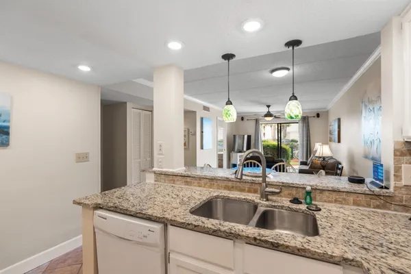 a kitchen with a sink a counter space appliances and cabinets