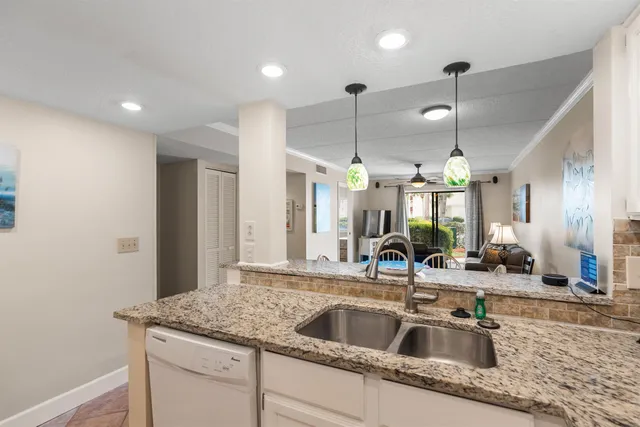 a kitchen with a sink a counter space appliances and cabinets