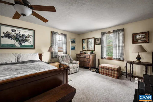 a spacious bedroom with a bed a couch and a large window