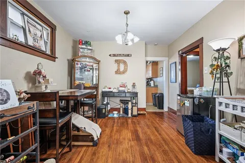 a view of a dining room with furniture a chandelier and wooden floor