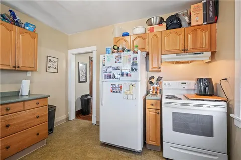 a view of a kitchen with fridge and wooden floor
