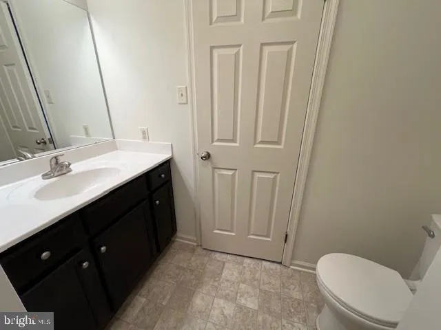 a bathroom with a sink a toilet a mirror and vanity