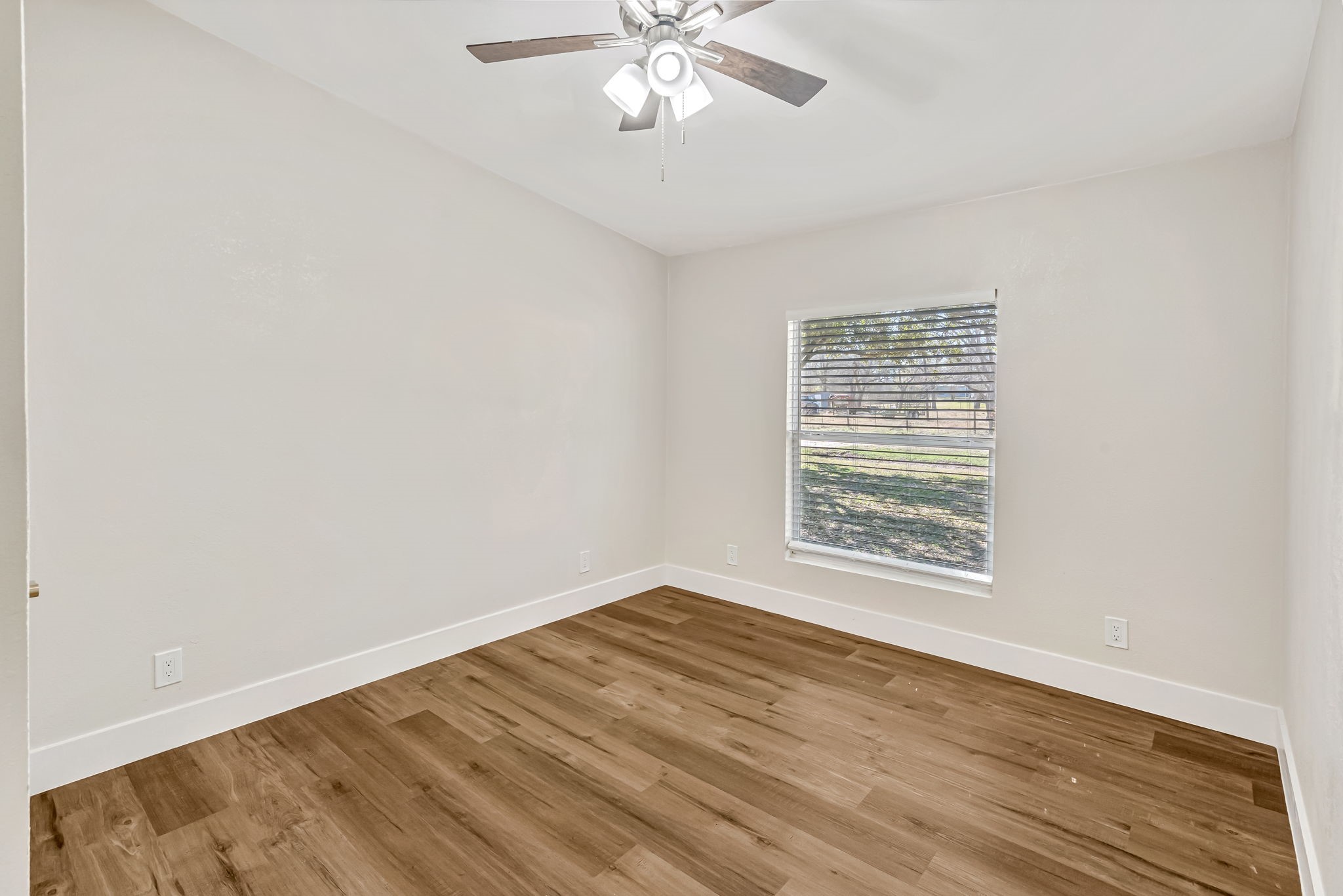 1491 Pecan Valley Road Wharton, TX 77488 - Photo 20 of 38 wooden floor in an empty room with a window