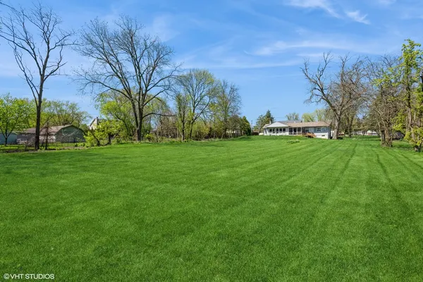a view of a field of grass and trees