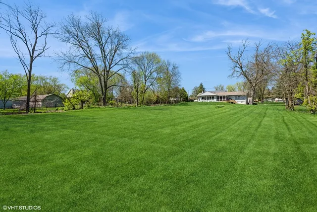 a view of a field of grass and trees