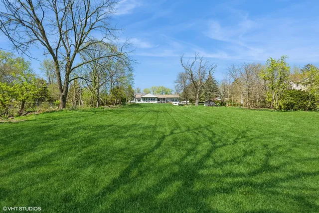 a backyard of a house with lots of green space and fountain