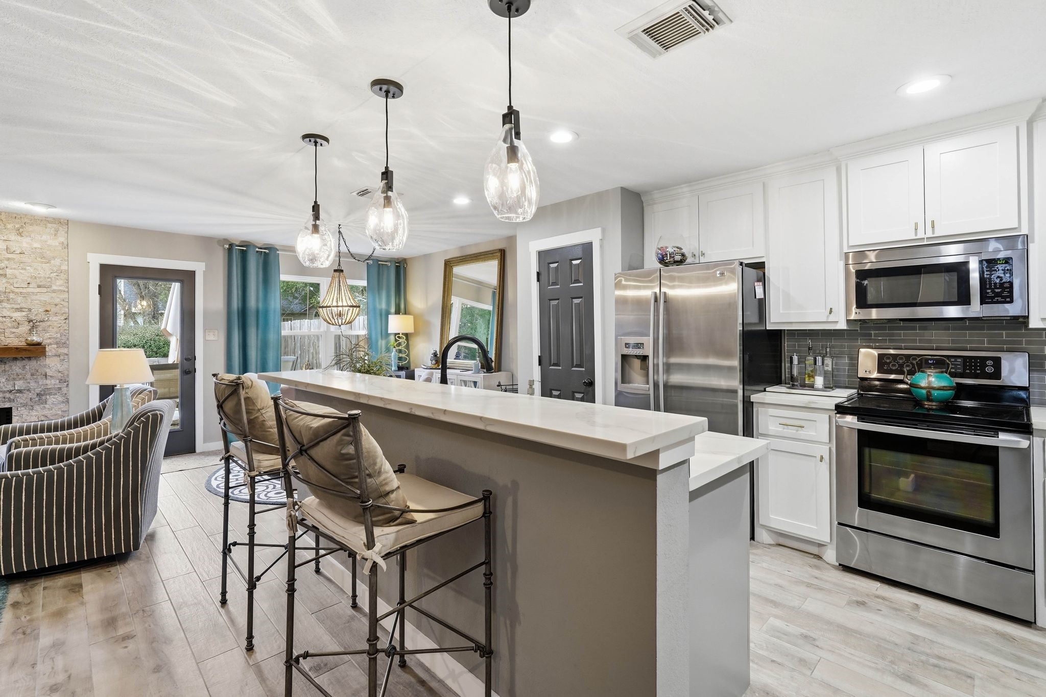 51 Wineberry Place Spring, TX 77382 - Photo 9 of 45 a kitchen with stainless steel appliances granite countertop a stove a sink a refrigerator a microwave oven with a dining table and chairs