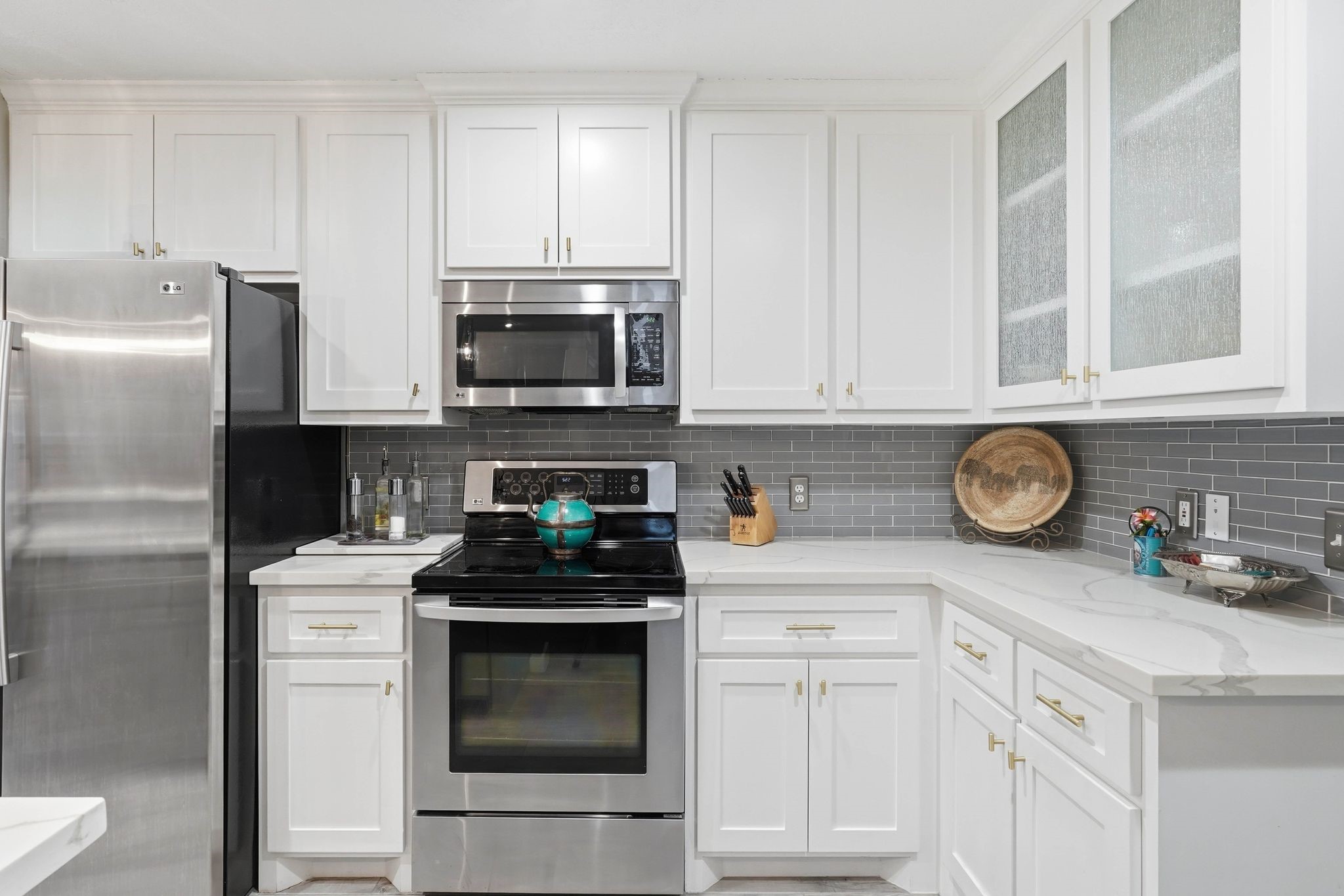 51 Wineberry Place Spring, TX 77382 - Photo 10 of 45 a kitchen with stainless steel appliances granite countertop white cabinets a stove a microwave and a refrigerator