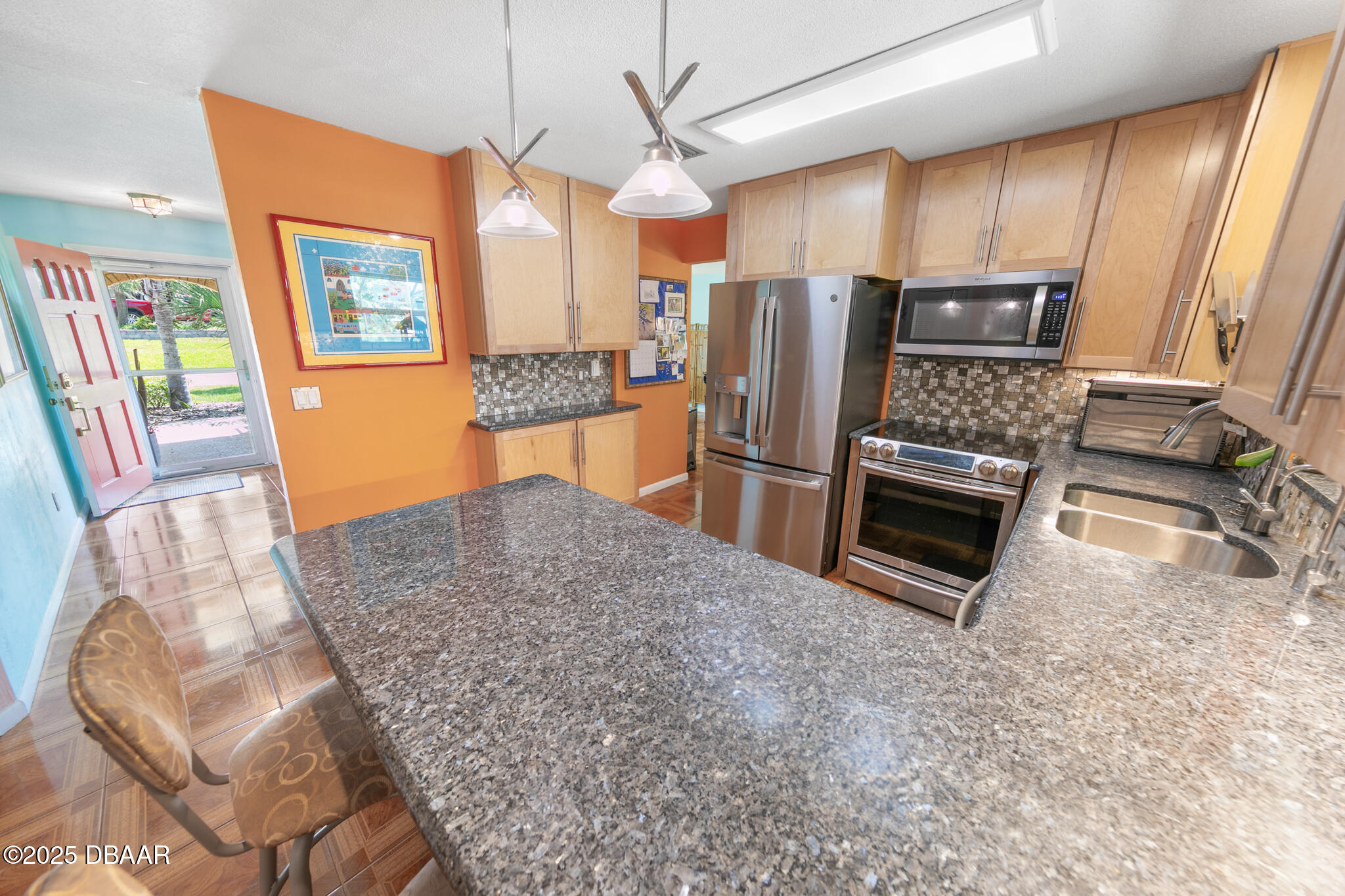 4350 Candlewood Lane Ponce Inlet, FL 32127 - Photo 8 of 60 a kitchen with stainless steel appliances granite countertop a refrigerator a stove a sink a dining table and chairs with wooden floor