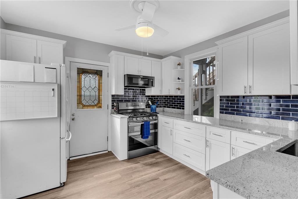 713 Clinton Place Pittsburgh, PA 15202 - Photo 11 of 31 a kitchen with white cabinets and stainless steel appliances