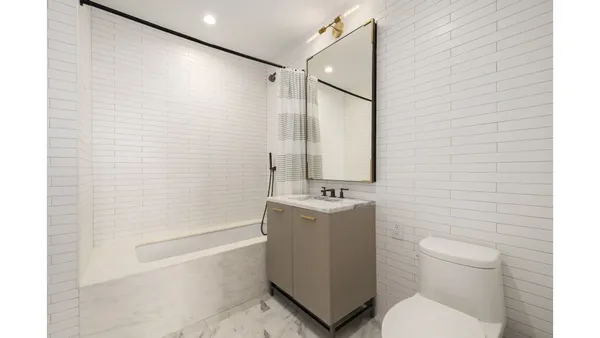 a bedroom with a bed and a large mirror