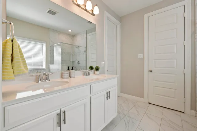 a bathroom with a double vanity sink a mirror and a bathtub