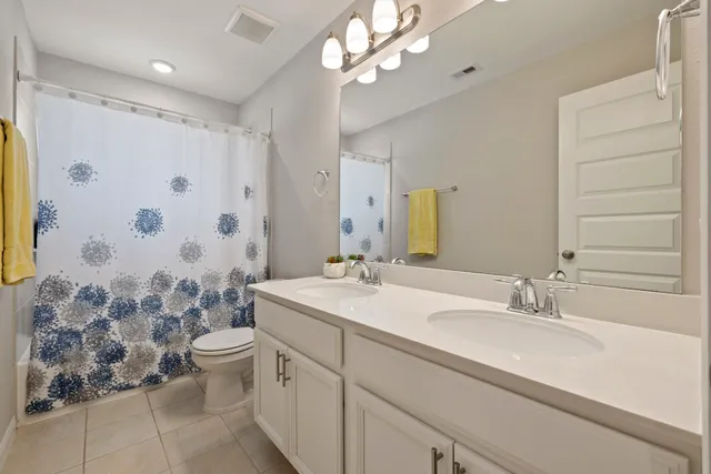 a bathroom with a double vanity sink mirror and shower