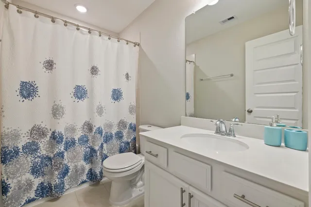 a bathroom with a sink a toilet and shower curtain