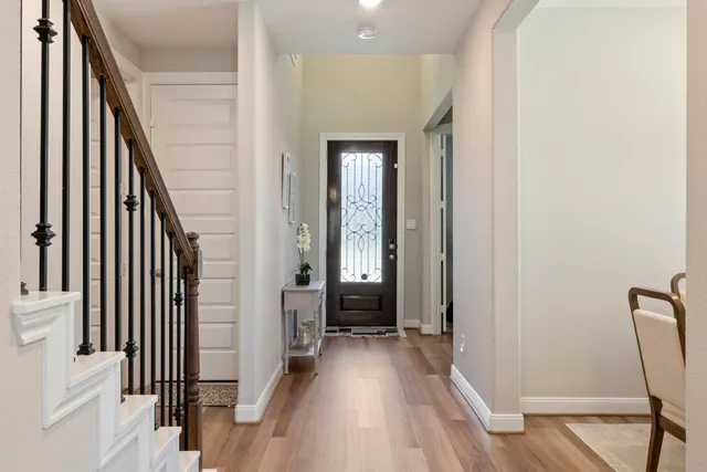 a view of a hallway with wooden floor and stairs