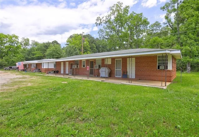 a view of a house with backyard and a patio