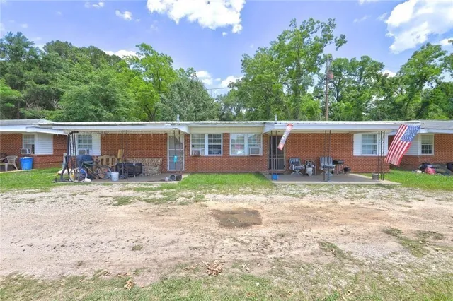 a view of house with backyard and a tree