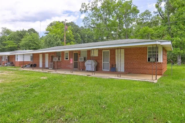 a view of a patio with table and chairs potted plants and large tree
