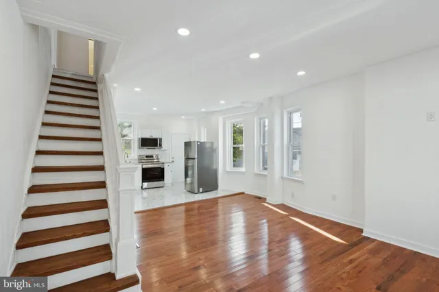 a living room with furniture a flat screen tv and kitchen view