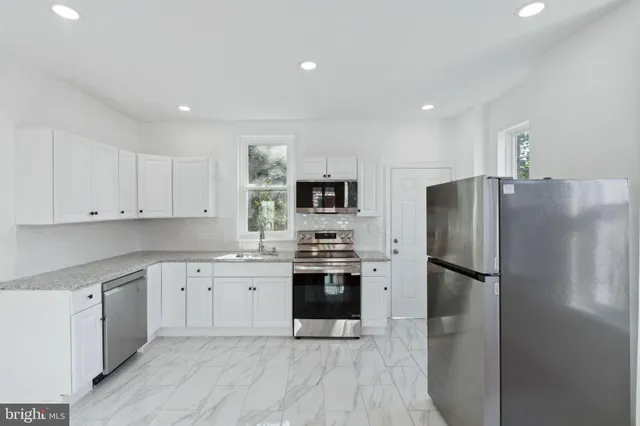a kitchen with stainless steel appliances a stove sink microwave and cabinets