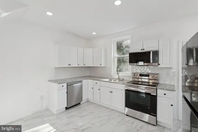 a kitchen with a sink cabinets and wooden floor