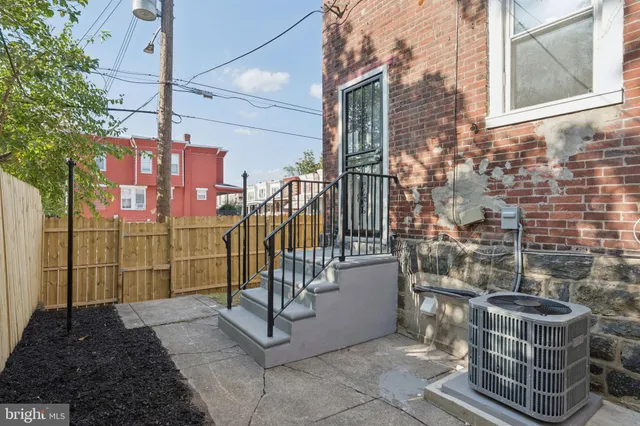 a view of a brick house with a small pool and sitting area